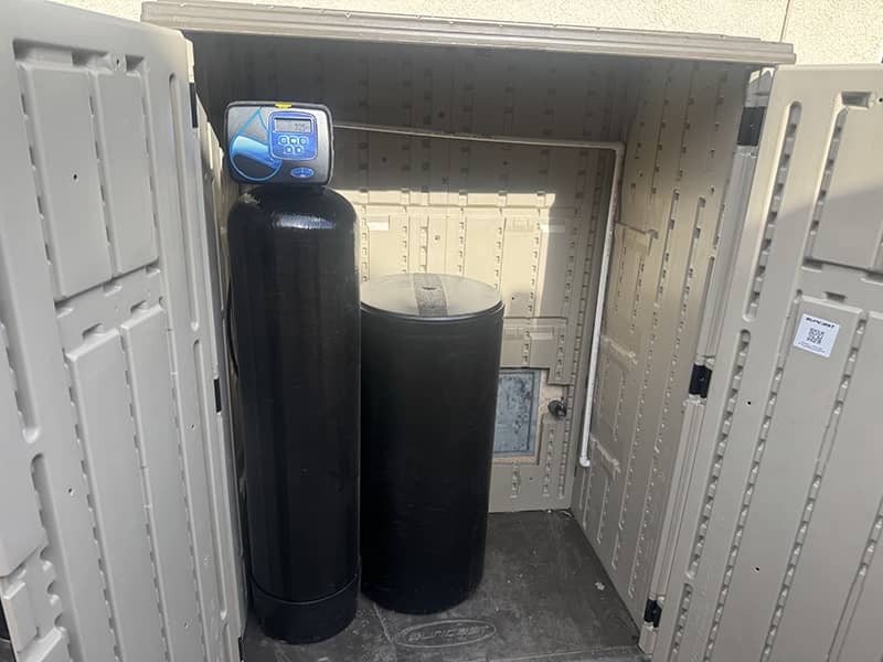Whole-house water softener system installed in an outdoor enclosure in Apple Valley, CA